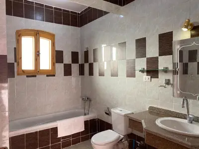 a bathroom with a toilet and a sink and a tub at Elsanosy Family Guest House - Luxor in Luxor