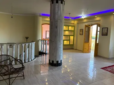 a room with a column and a chair and a staircase at Elsanosy Family Guest House - Luxor in Luxor