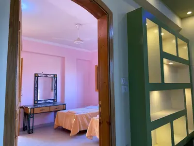 a room with a bed and a dresser and a mirror at Elsanosy Family Guest House - Luxor in Luxor