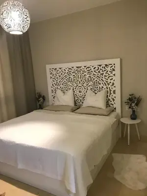 a bedroom with a large white bed with a chandelier at Jutta Deluxe 2-Bedroom-Apartment Mangroovy-M7 El Gouna in Hurghada