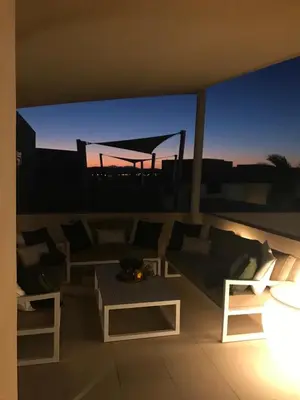 a living room with a couch and tables on a balcony at Jutta Deluxe 2-Bedroom-Apartment Mangroovy-M7 El Gouna in Hurghada