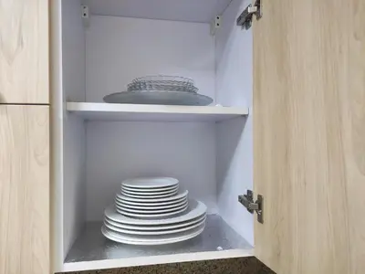 a stack of plates in a cupboard at Full Apartment with Panoramic View of Hurghada in Hurghada