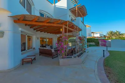 a patio of a house with a bench and flowers at 4 Bedroom Villa with Heated Pool, Jacuzzi & Lagoon View in Phase 4 in Hurghada