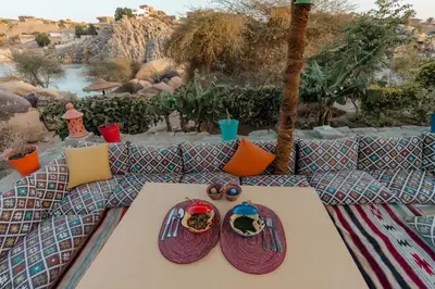 a table with two hats and colorful pillows on it at Krouma Camp & Ecolodge in Aswan