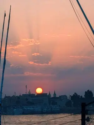 a sunset over a city with the sun in the sky at Al Ramla Guest House in Luxor