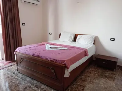 a bedroom with a bed with a purple bedspread at Al Ramla Guest House in Luxor