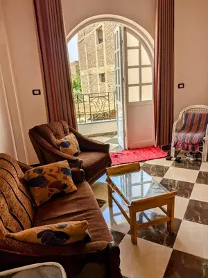 a living room with a couch and a glass table at Al Ramla Guest House in Luxor