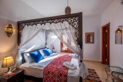 a bedroom with a large canopy bed with blue pillows at Charming Lagoon Villa with pool Egyptian Style -Sabina 117 in Hurghada