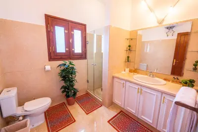 a bathroom with a toilet and a sink and a mirror at Charming Lagoon Villa with pool Egyptian Style -Sabina 117 in Hurghada