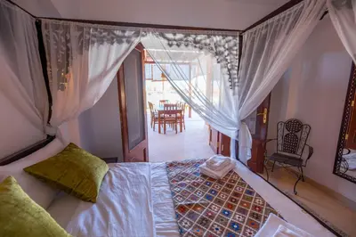 a bedroom with a bed and a dining room at Charming Lagoon Villa with pool Egyptian Style -Sabina 117 in Hurghada