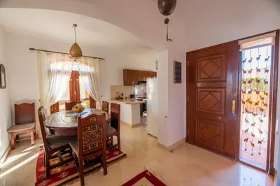 a kitchen and dining room with a table and a door at Charming Lagoon Villa with pool Egyptian Style -Sabina 117 in Hurghada