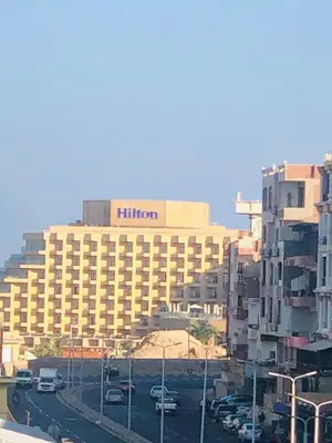 a hotel with a hilton sign on top of a building at Rony's Ocean View Family Apartment in Hurghada