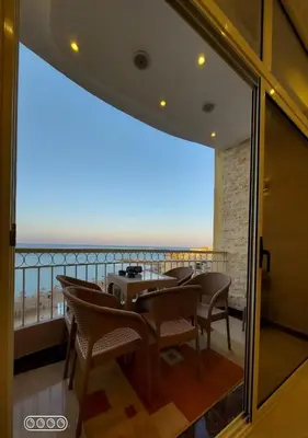 a dining room with a view of the ocean at Rony's Ocean View Family Apartment in Hurghada