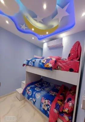 a bedroom with two bunk beds and a ceiling with a moon at Rony's Ocean View Family Apartment in Hurghada