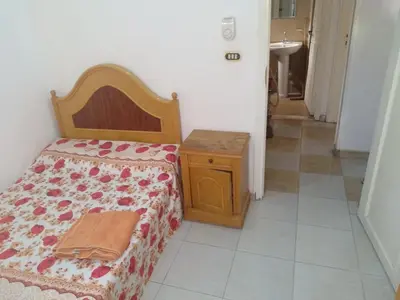 a bedroom with a bed and a table and a sink at Bob Marley Homestay in Hurghada