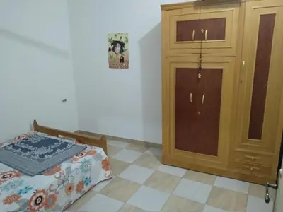 a bedroom with a closet and a bed and a cabinet at Bob Marley Homestay in Hurghada