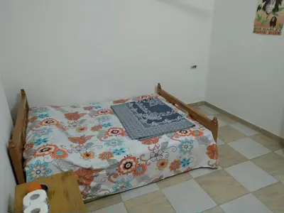a small bed with a blanket on it in a room at Bob Marley Homestay in Hurghada