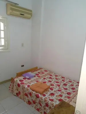 a bedroom with a bed with a flowered blanket at Bob Marley Homestay in Hurghada