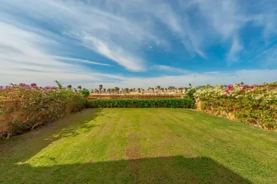 a large grass field with flowers and bushes at VESTA - Soma Bay Residence in Hurghada