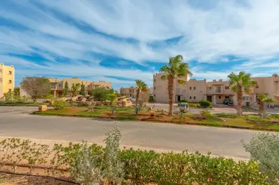 a street in a city with palm trees and buildings at VESTA - Soma Bay Residence in Hurghada