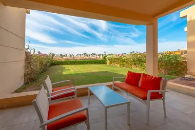 a patio with chairs and a table and a large window at VESTA - Soma Bay Residence in Hurghada