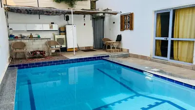a large blue swimming pool in a house at Tara Apartments in Luxor