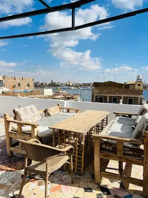 a patio with a table and chairs on a roof at Tara Apartments in Luxor