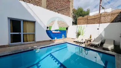 a swimming pool with a mural of a sailboat at Tara Apartments in Luxor