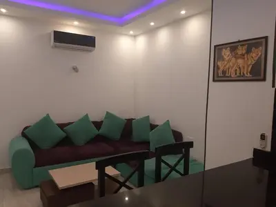 a living room with a couch with green pillows at apartman Marek in Hurghada