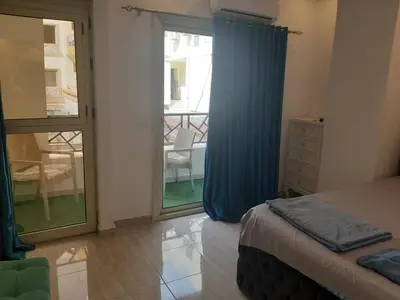 a bedroom with a bed and a sliding glass door at apartman Marek in Hurghada