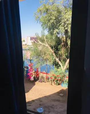 a view from a window of a beach with a tree at Shipa Nubian Guest House in Aswan