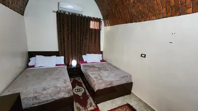 a small room with two beds and a window at Dara guest House in Aswan