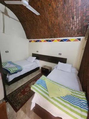 a room with two beds and a ceiling at Dara guest House in Aswan