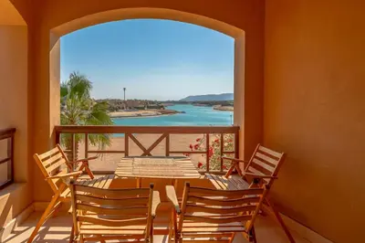 a table and chairs on a balcony with a view of the beach at Sabina Classy 1 BR Apartment Lagoon view & Pool El Gouna in Hurghada