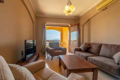 a living room with a couch and a table and a tv at Sabina Classy 1 BR Apartment Lagoon view & Pool El Gouna in Hurghada