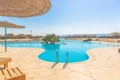 a large swimming pool with blue water in a resort at Sabina Classy 1 BR Apartment Lagoon view & Pool El Gouna in Hurghada