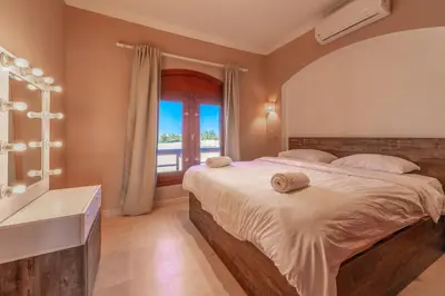 a bedroom with a large bed and a window at Sabina Classy 1 BR Apartment Lagoon view & Pool El Gouna in Hurghada