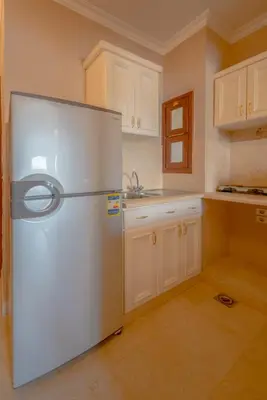 a white refrigerator in a kitchen with white cabinets at Sabina Classy 1 BR Apartment Lagoon view & Pool El Gouna in Hurghada