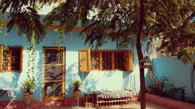 a blue building with a table and chairs in front of it at Villa Diletta Luxor in Luxor