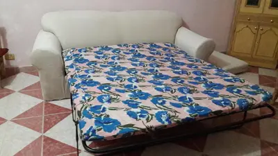 a bed with blue flowers on it in a room at Villa Diletta Luxor in Luxor