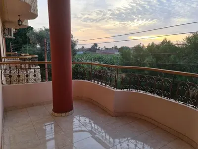 a balcony with a column and a view of a field at Moonlight Home in Luxor