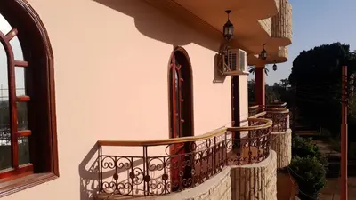 a balcony of a house with a wrought iron railing at Moonlight Home in Luxor