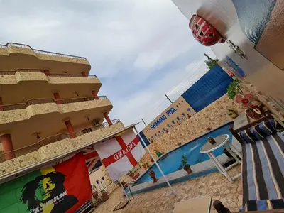 a view of a hotel with a pool and a building at Moonlight Home in Luxor