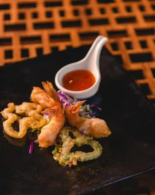 a plate of food with shrimp and a tablespoon of sauce at The Grand Resort in Hurghada