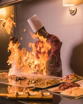 a chef cooking pizza in a fire oven at The Grand Resort in Hurghada