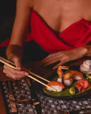 a woman in a red dress cutting a plate of food at The Grand Resort in Hurghada