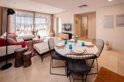 a living room with a table and chairs at Earthy & Tranquil 1 BDR Mangroovy Free Pool & Beach Access in Hurghada