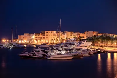 a group of boats docked in a harbor at night at Earthy & Tranquil 1 BDR Mangroovy Free Pool & Beach Access in Hurghada
