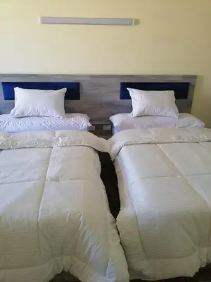 two beds sitting next to each other in a room at florenza khamsin studio in hurghada pool view in Hurghada
