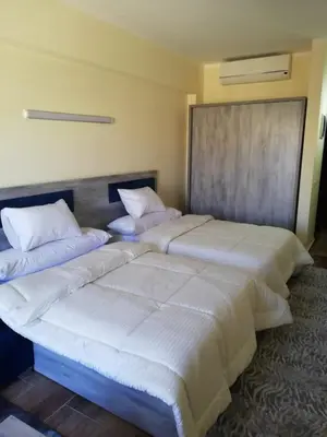 two beds sitting next to each other in a room at florenza khamsin studio in hurghada pool view in Hurghada